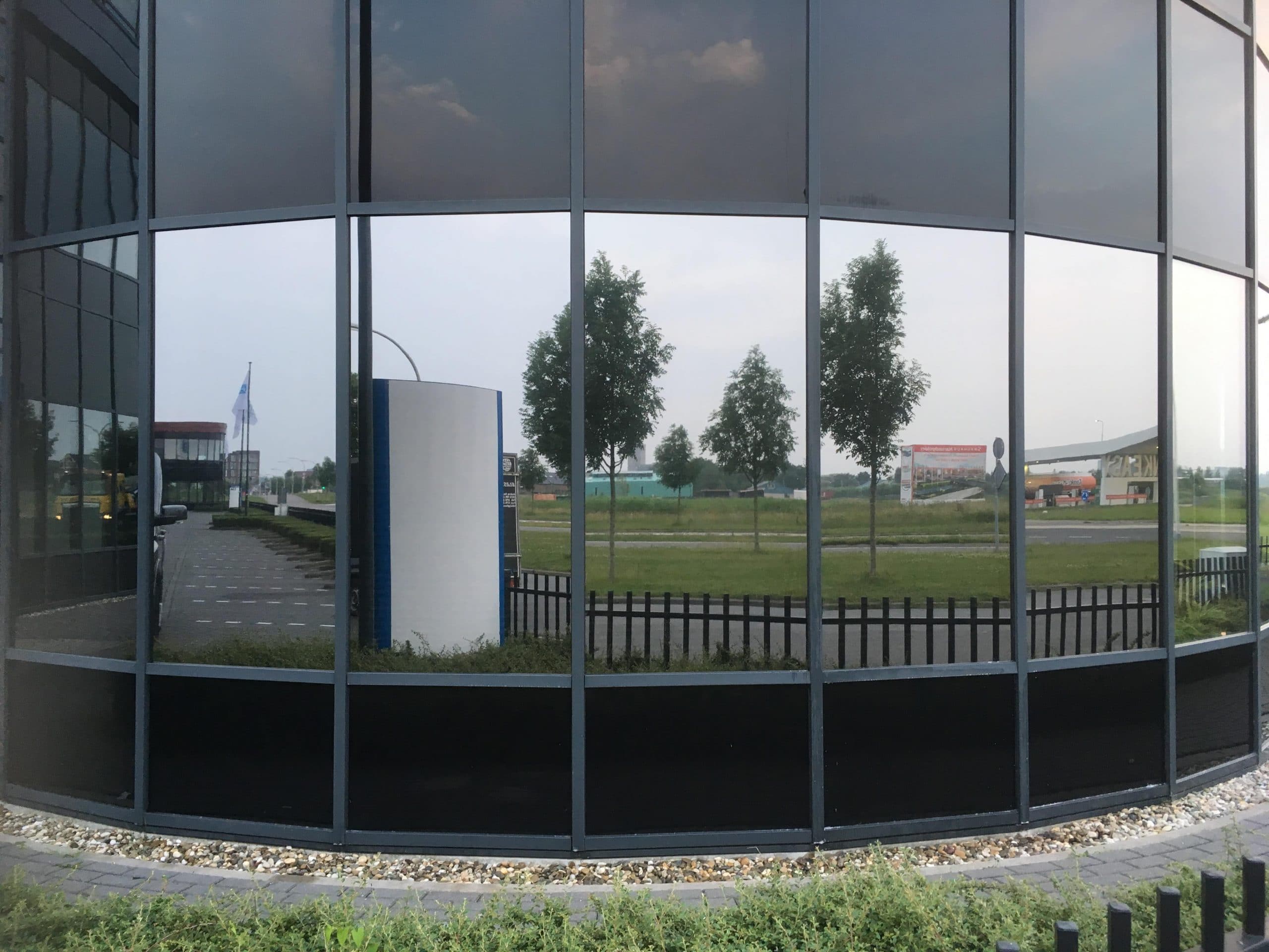 Den Hoorn - Sunblock Stainless Steel 25 gemonteerd op de ramen van een bedrijfsruimte om de overmatige zonnewarmte buiten te houden en de hinderlijke schittering te reduceren